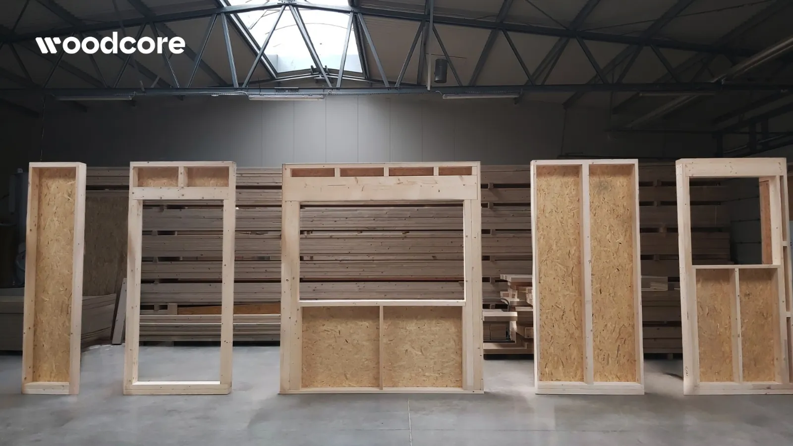 Prefabrykowane moduły ścian z ciężkiego szkieletu drewnianego WoodCore House w hali produkcyjnej
